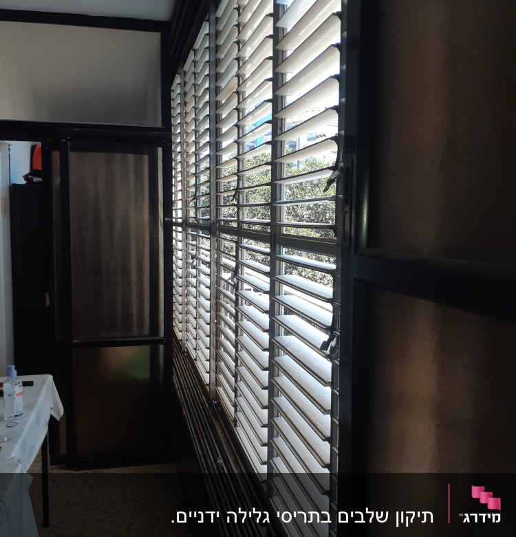 תריסים אופקיים לבנים על חלון זכוכית